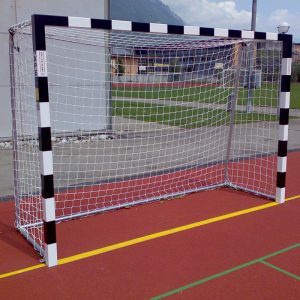 Handballtor mit schwarz/weiss Torrahmen auf rotem Pausenplatz