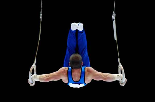 Willkommen bei Activa Sport. Turner zeigt sein Können in der Luft an den Ringen.