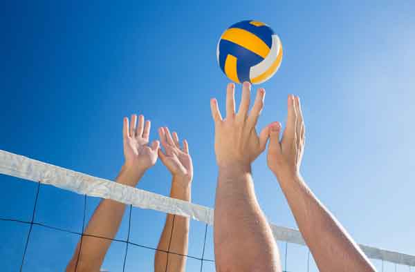 Willkommen bei Activa Sport. Volleyball: 2 paar Hände blocken am Netz, der Ball noch in der Luft.
