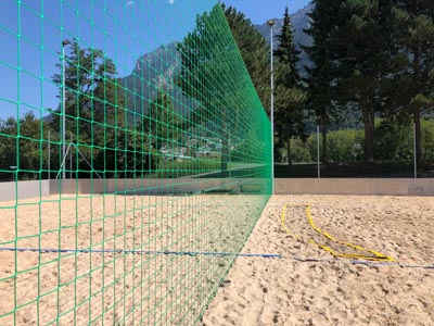 grünes Schutznetz auf Sand für Beachvolleyball