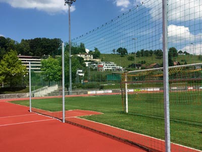 Schutznetz an Drahtseil auf Sportplatz, trennt Bereiche Fussball und Sportplatz